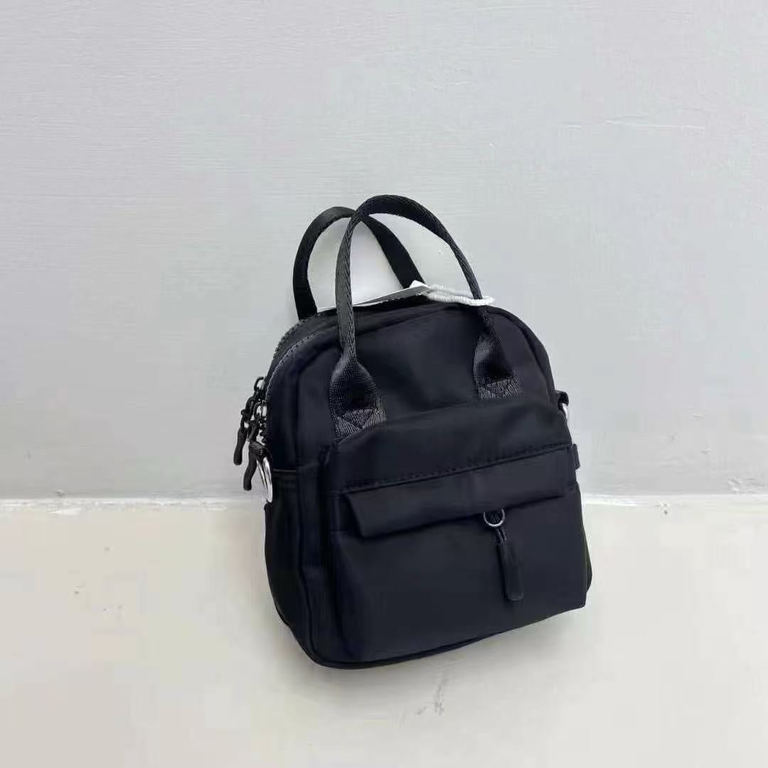 Black backpack on a light gray background,A high-fashion shot of a woman in a black skirt and white shirt, holding a stylish, minimalist brown bag. The image is professionally lit in a studio against a clean white background, with a strong focus on the bag's sleek design and texture. The photo emphasizes a sophisticated and modern aesthetic, perfect for luxury or premium lifestyle brands.