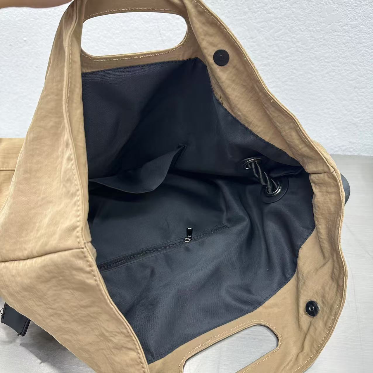 Close-up of a beige stroller seat with black interior on a light gray background,High-quality red tote bag for women and girls from a new Indian fashion brand. Features a unique top-fold flap design and sturdy braided black rope handles. Perfect for carrying laptops and essentials, making it a stylish and functional bag for office, college, or casual outings in India. A chic and trending design for the modern Indian woman, available online with free shipping.