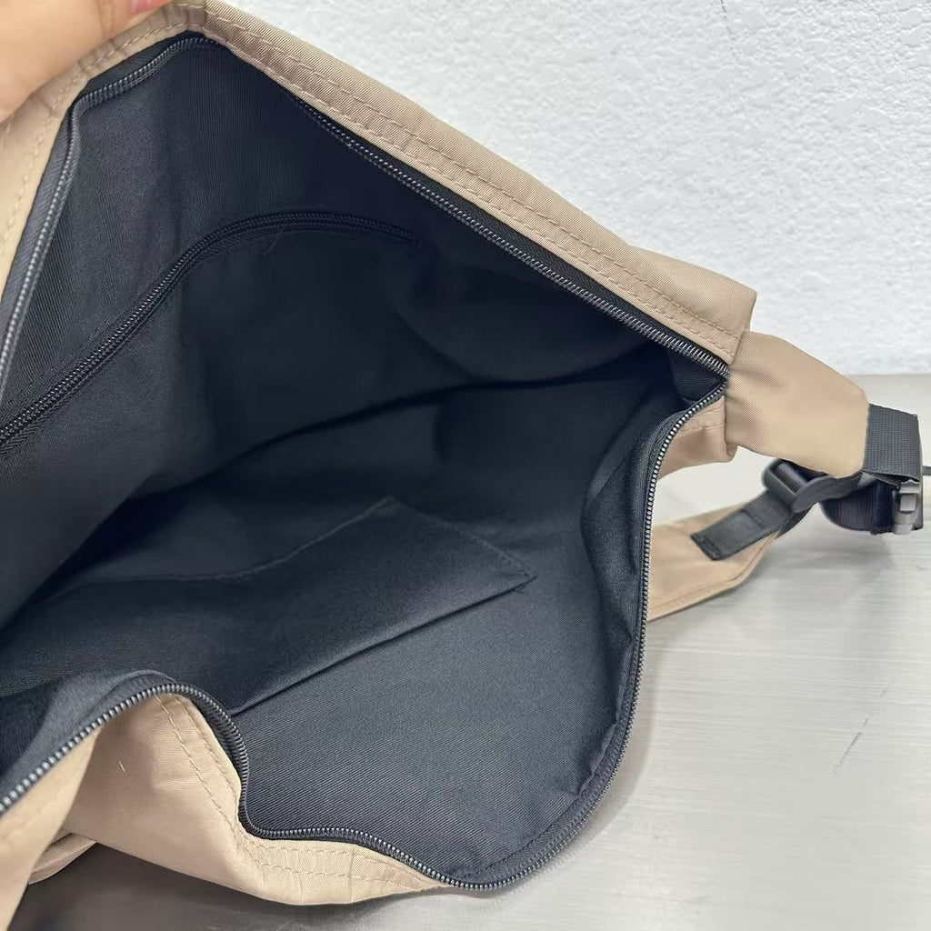 Open beige bag with black interior on a light gray background,Convertible nylon tote bag with detachable crossbody strap, zippered front pocket, and main compartment. Available in olive green, black, and beige.