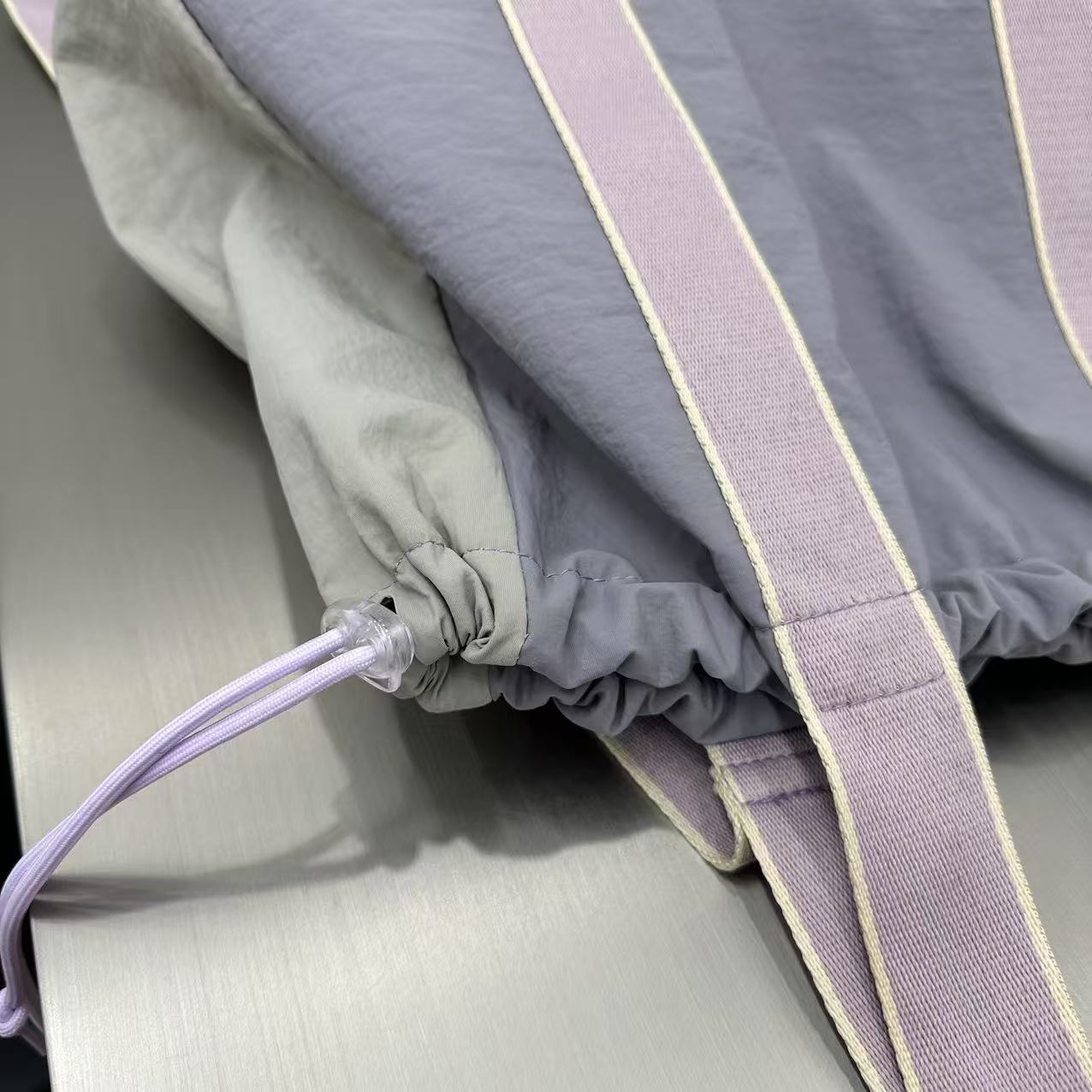 Gray car seat cover with a purple strap and cable on a gray background,A versatile and stylish tote bag for women, perfect for the Indian market, shot from a side angle showing the product in use. The bag is made from a durable, high-quality fabric and features a casual, comfortable design with shoulder straps. This fashion accessory is ideal for a daily commute, college, or casual outings. It's a must-have for those seeking a practical yet trendy handbag in India.