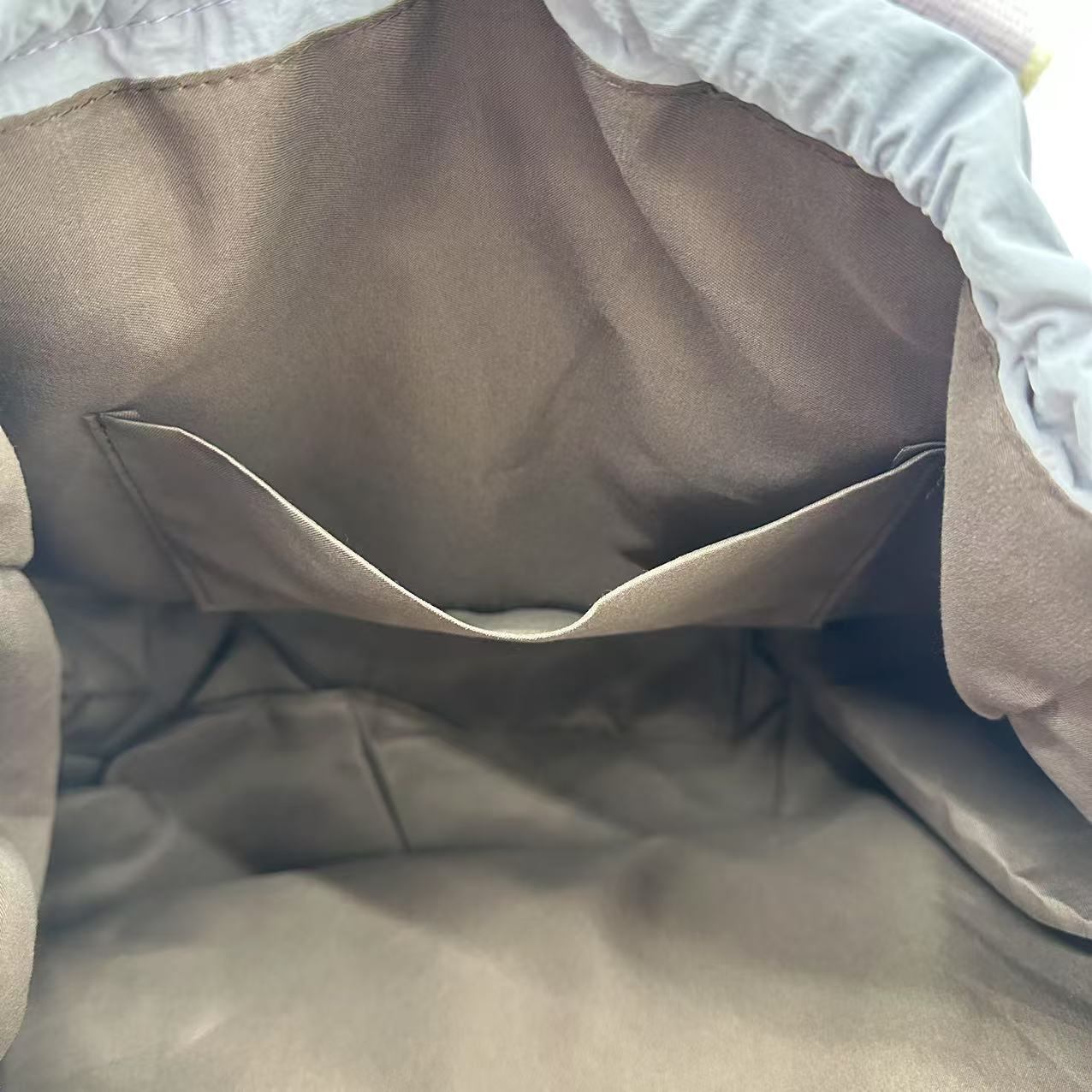 Close-up of a beige quilt with white borderA versatile and stylish tote bag for women, perfect for the Indian market, shot from a side angle showing the product in use. The bag is made from a durable, high-quality fabric and features a casual, comfortable design with shoulder straps. This fashion accessory is ideal for a daily commute, college, or casual outings. It's a must-have for those seeking a practical yet trendy handbag in India.