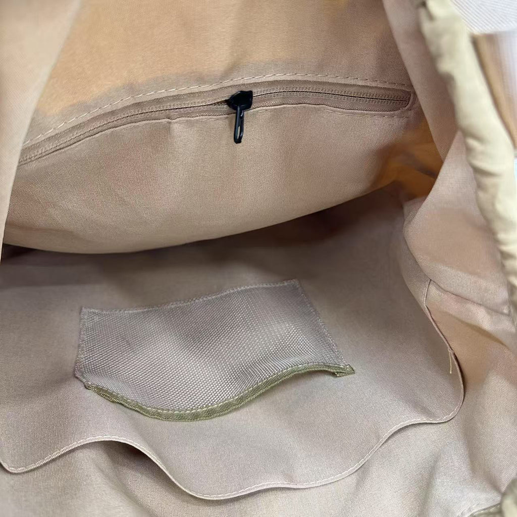 Close-up of beige fabric with a zipper and mesh pocket"Stylish khaki drawstring tote bag with multiple compartments and adjustable straps, perfect for daily use, shopping, and travel in India. Features include a secure zippered pocket, spacious main compartment, and comfortable shoulder straps. Ideal for fashion-conscious individuals seeking a versatile and trendy bag."