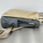 Folded beige and gray fabric bag on a metallic surface with a light grayStylish travel backpack, durable everyday bag, versatile shoulder tote, convertible backpack purse, waterproof utility bag, modern casual rucksack, ergonomic daypack, trendy laptop bag, multi-functional women's backpack, secure anti-theft design, spacious college bag, fashion-forward accessory, urban commuter pack, comfortable carry-all, premium quality satchel, practical work bag, chic student backpack, easy-access travel es background