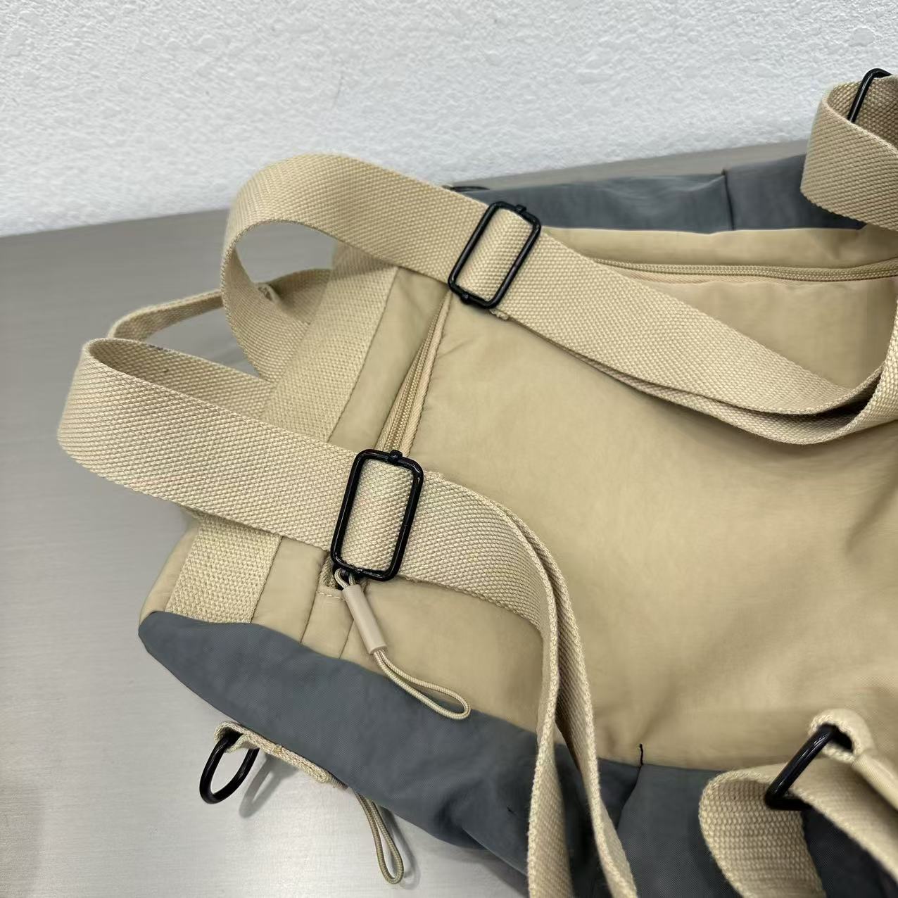 Beige and gray bag with straps on a light backgroundStylish travel backpack, durable everyday bag, versatile shoulder tote, convertible backpack purse, waterproof utility bag, modern casual rucksack, ergonomic daypack, trendy laptop bag, multi-functional women's backpack, secure anti-theft design, spacious college bag, fashion-forward accessory, urban commuter pack, comfortable carry-all, premium quality satchel, practical work bag, chic student backpack, easy-access travel essential, organized personal ite