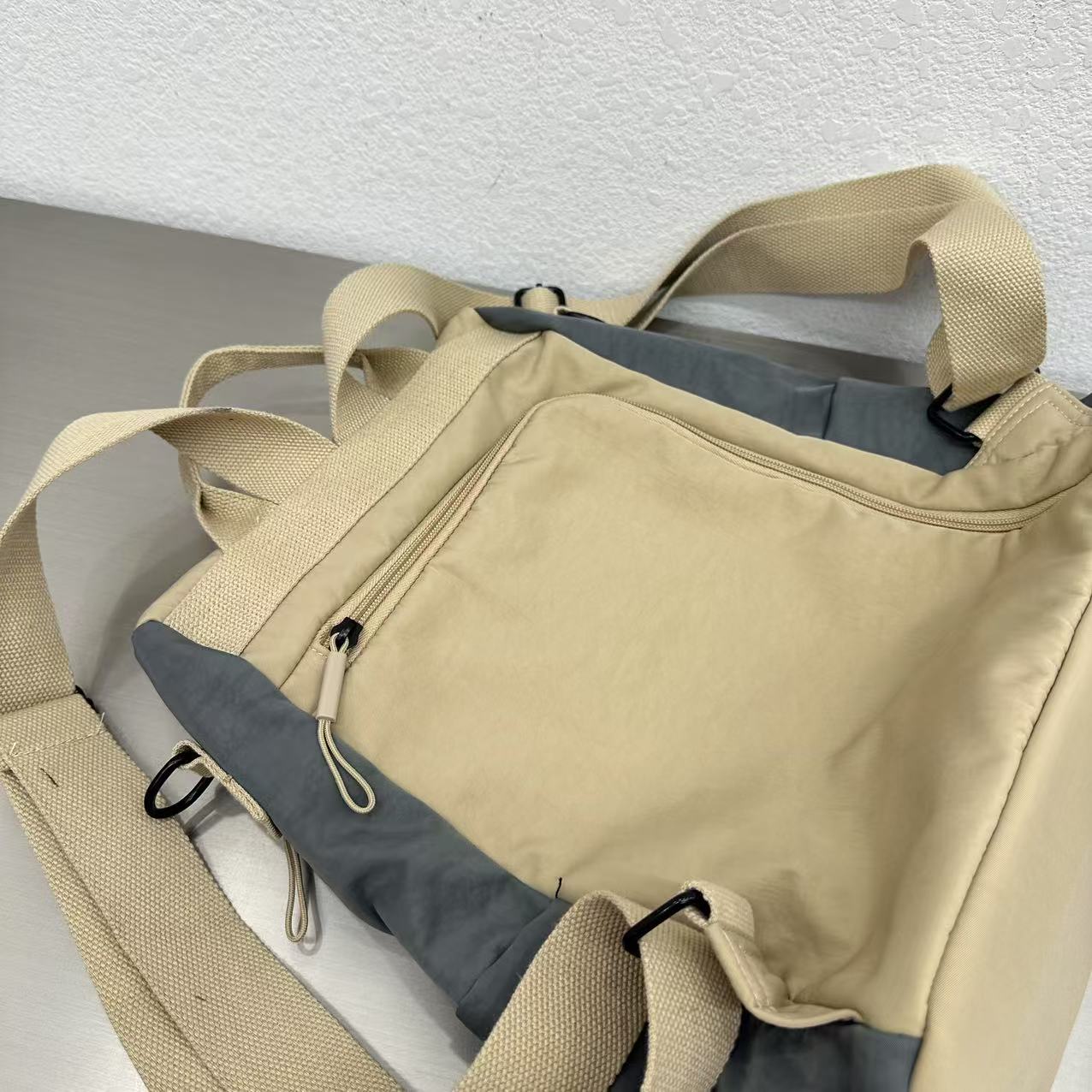 Beige duffel bag with gray interior on a white surfaceStylish travel backpack, durable everyday bag, versatile shoulder tote, convertible backpack purse, waterproof utility bag, modern casual rucksack, ergonomic daypack, trendy laptop bag, multi-functional women's backpack, secure anti-theft design, spacious college bag, fashion-forward accessory, urban commuter pack, comfortable carry-all, premium quality satchel, practical work bag, chic student backpack, easy-access travel essential, organized personal i