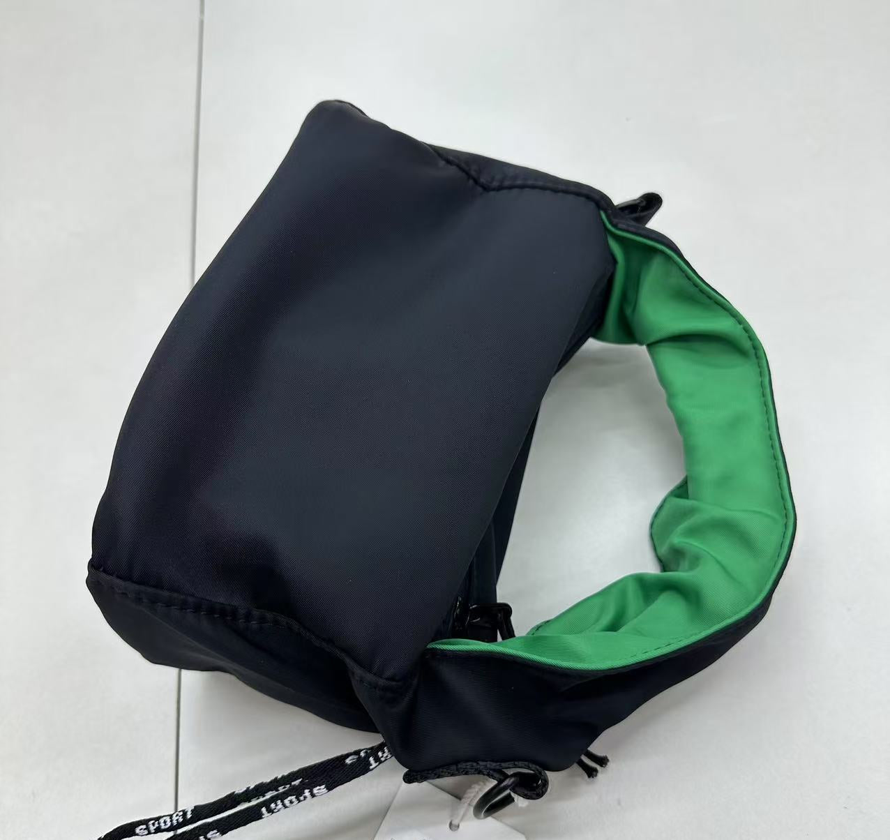 Black drawstring bag with green interior on a white background"Black waterproof polyester mini tote bag with stylish green lining, lightweight and durable design, adjustable crossbody strap and spacious compartments for wallet, phone, cosmetics and daily essentials. Perfect handbag for women in India for office, college, travel, shopping, and everyday use. Premium quality ladies tote bag available online at best price in India, versatile small carry bag for students, professionals, and travelers."