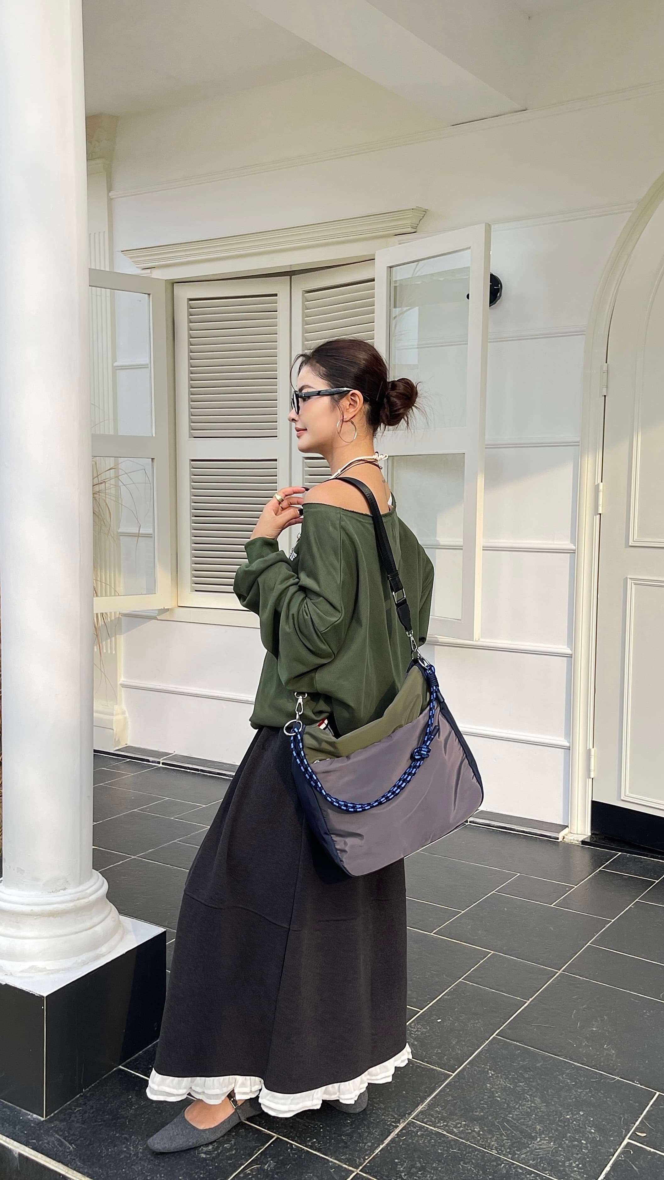Woman holding a gray bag with blue accents in a white room with columnsMulti-pocket travel tote bag with 20-litre capacity and compact dimensions (35 x 35 x 10 cm), featuring a wide adjustable strap and color-blocked utility design. Lightweight, durable, and ideal for travel, college, or daily use. A high-performance everyday essential from Tales of Totes – built for comfort, style, and smart organization in India’s fast-paced lifestyle."
