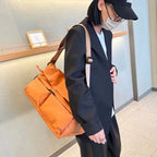 Brown backpack on a white background,A padded, water-resistant shoulder bag with a roomy interior, zip closure, and adjustable strap, designed for everyday carry and positioned as a stylish alternative to popular Indian brands like Zouk, Miraggio, Lavie, Caprese, and DailyObjects.