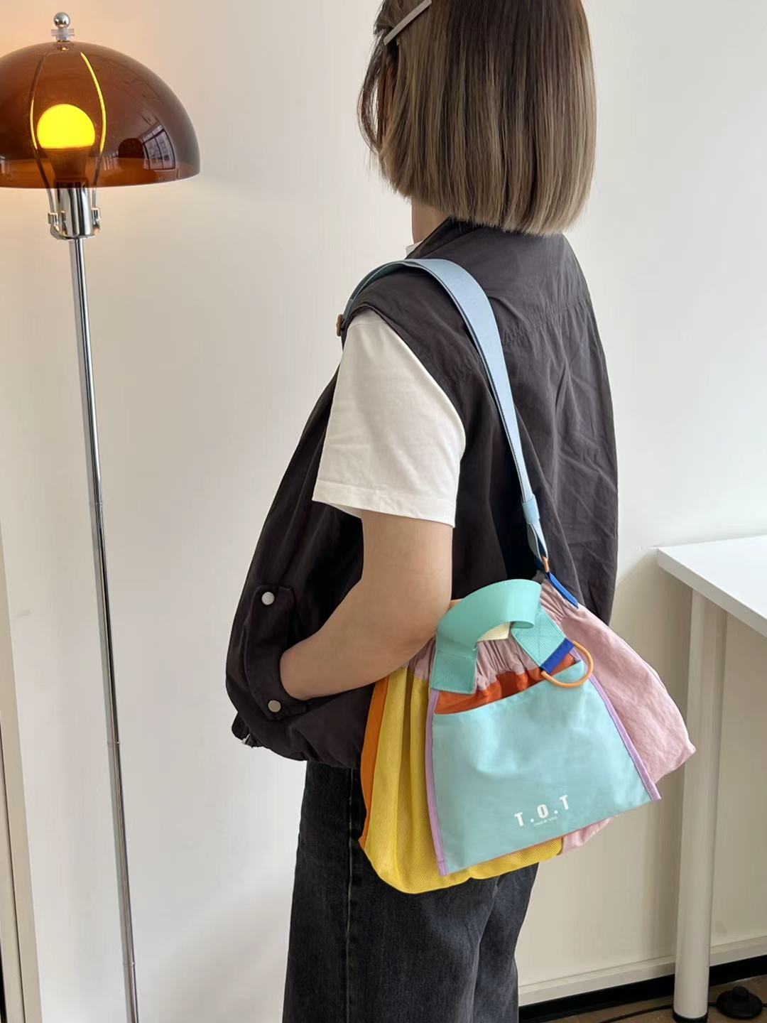 Trendy multi-color casual college tote bag with mesh detailing and adjustable straps.