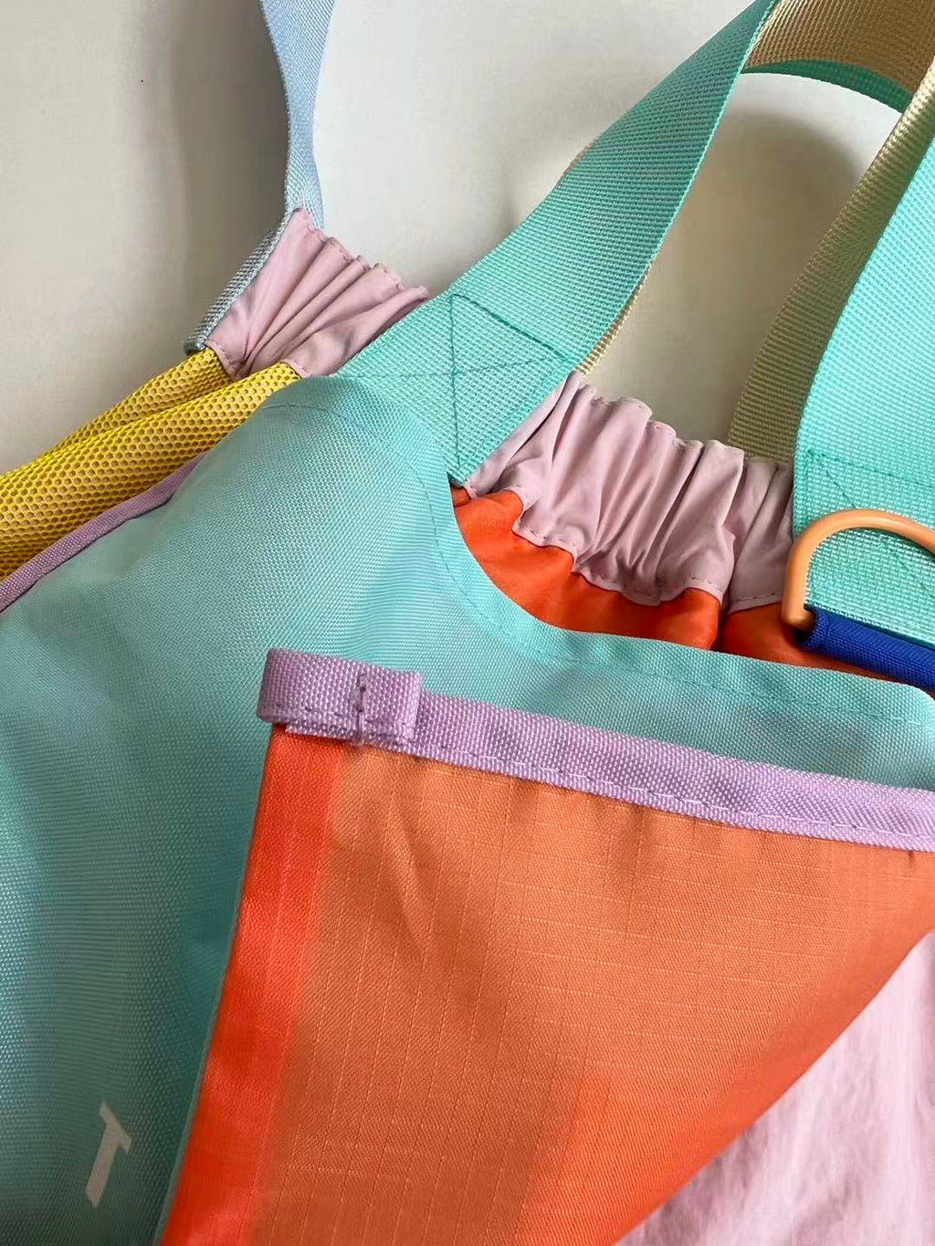 Trendy multi-color casual college tote bag with mesh detailing and adjustable straps.