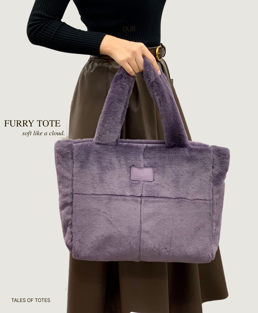 Person holding a purple furry tote bag with 'Furry Tote' text on a light gray background.