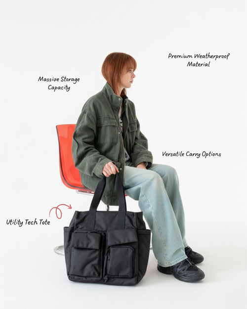 Person holding a black utility tech tote with text highlighting features on a white background