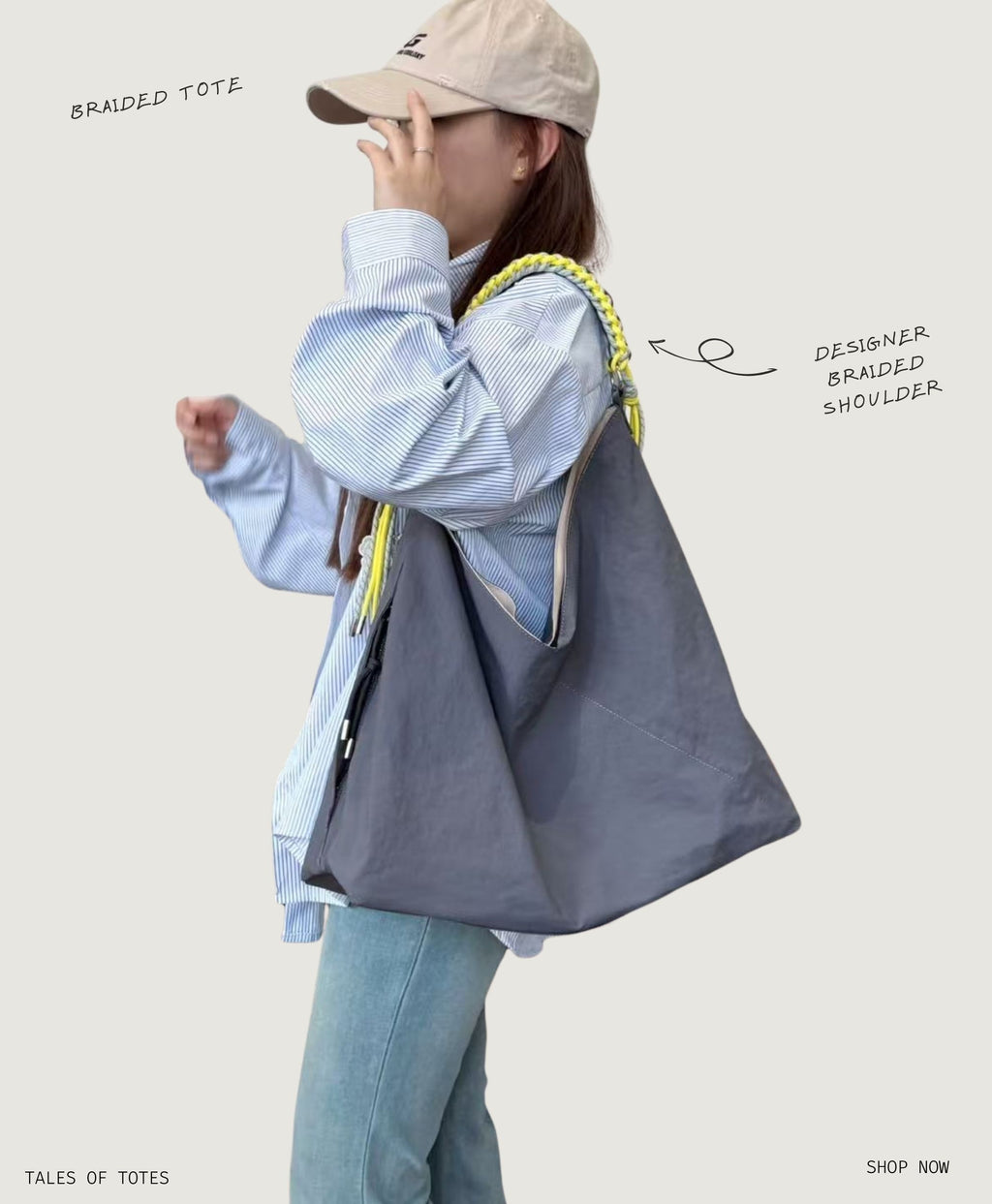Person holding a gray tote bag with braided shoulder strap on a light background