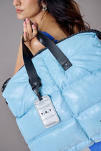 Light blue puffer jacket with a visible brand tag on a neutral background