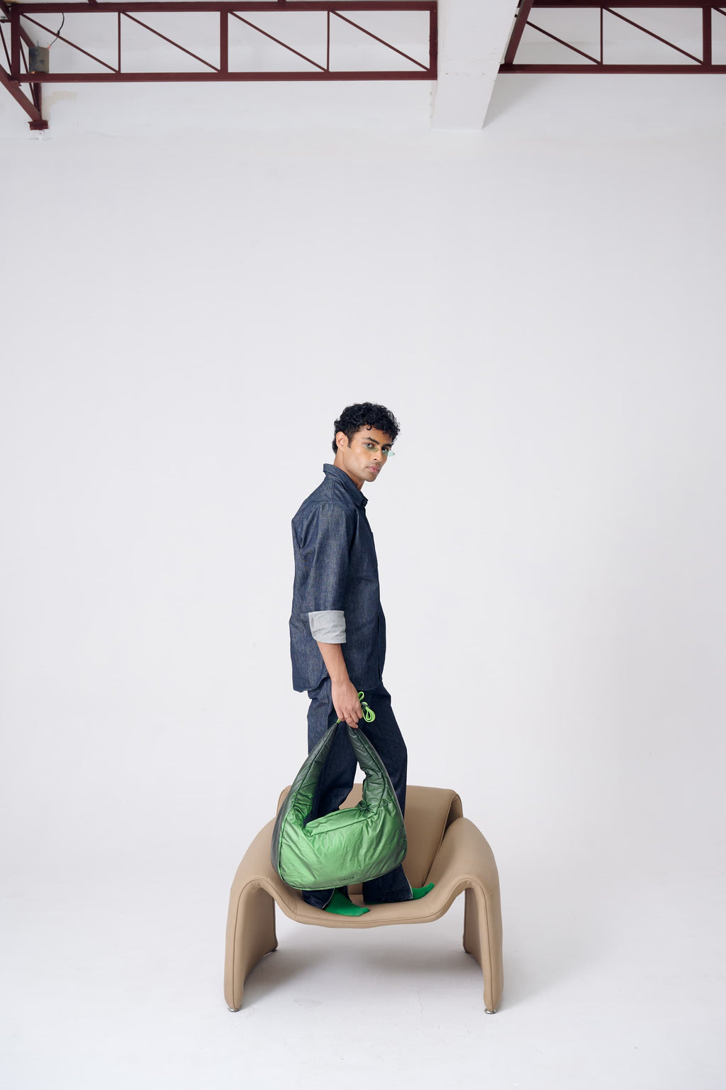 Person holding a green bag on a white background