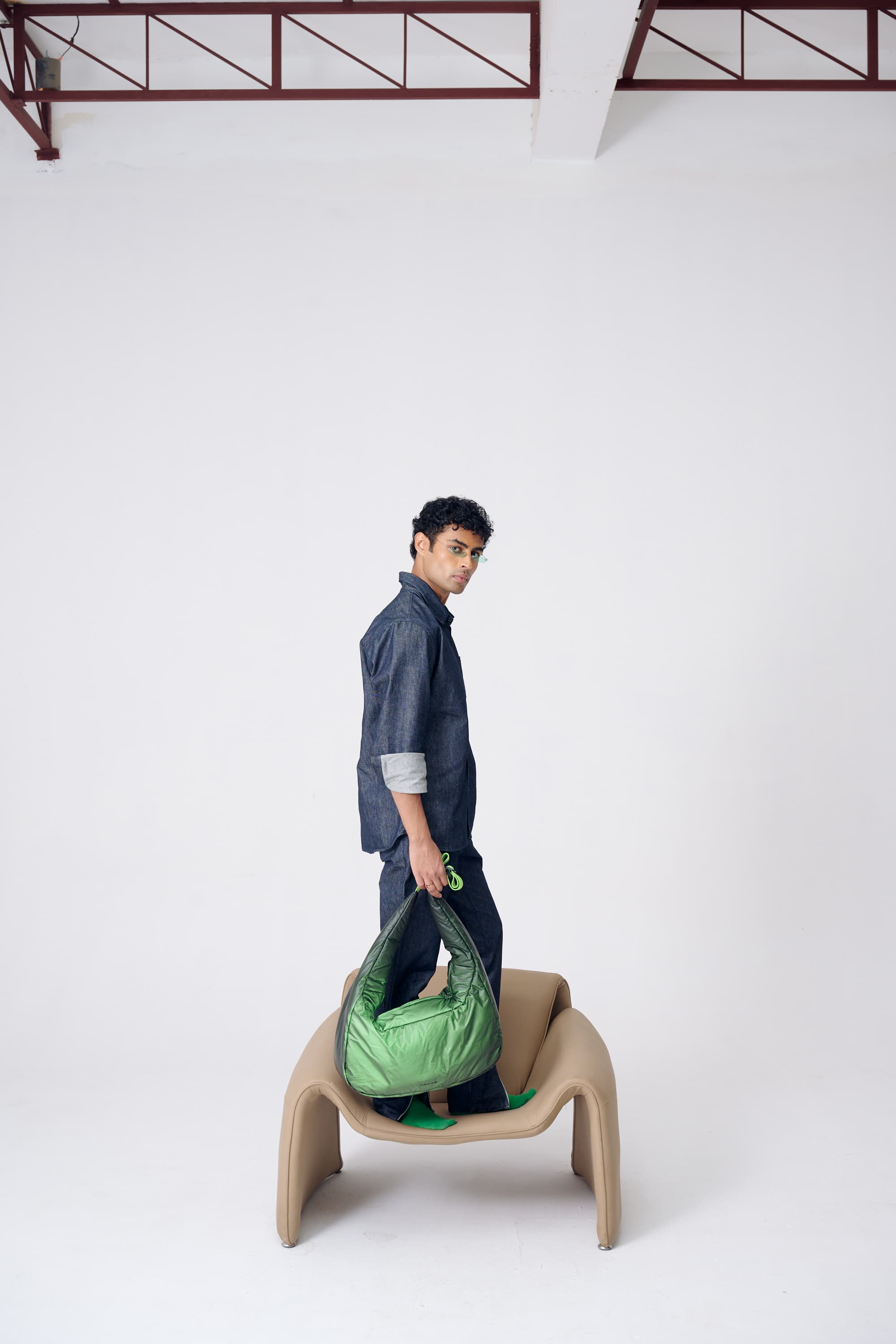 Person holding a green bag on a white background