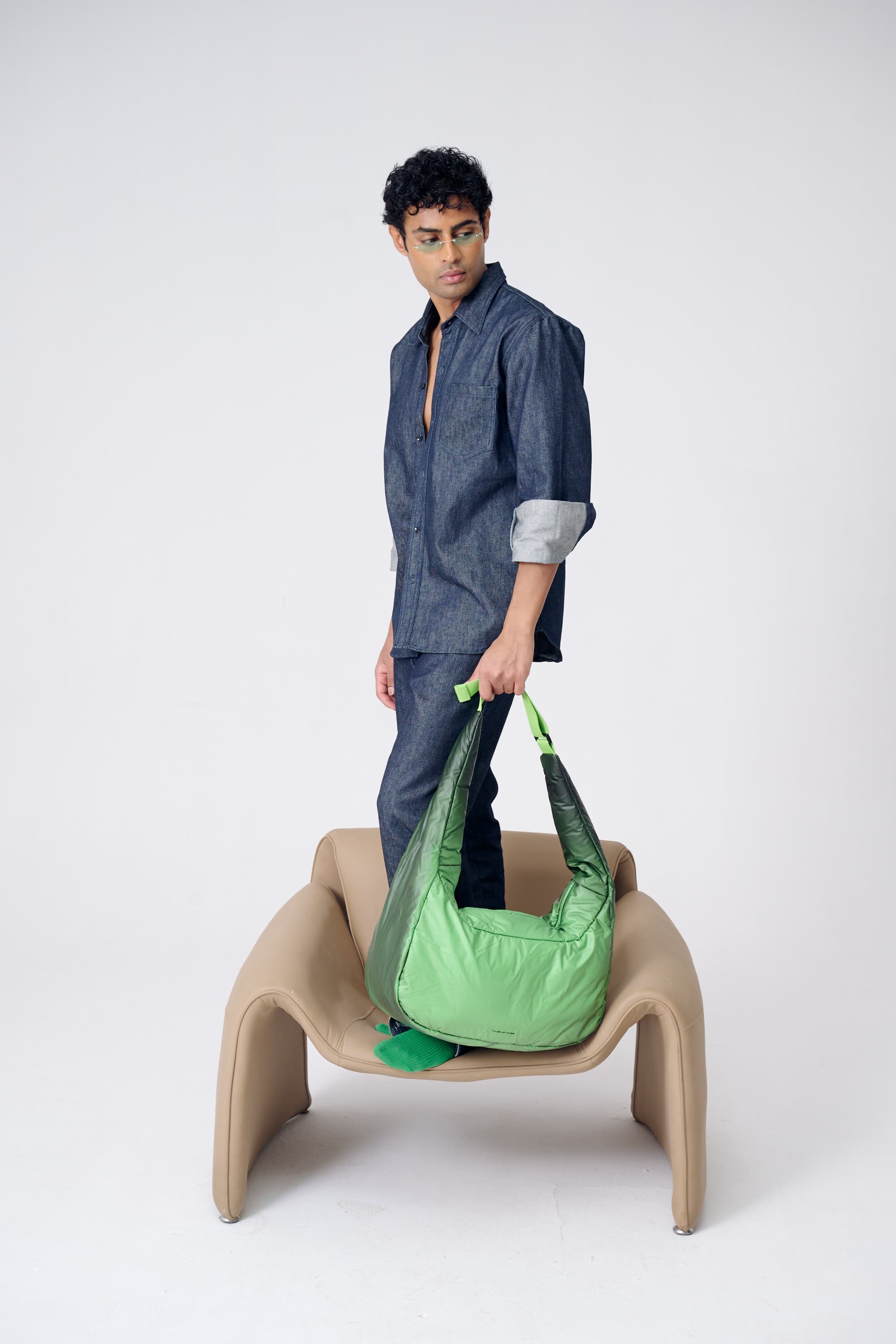 Person holding a green bag on a white background