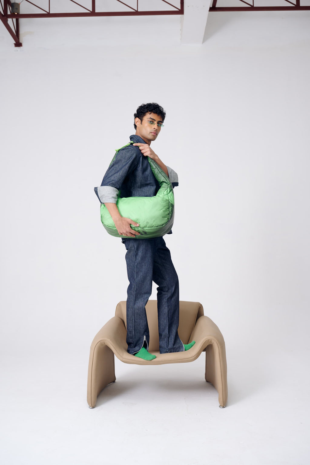 Person holding a green bag on a white background