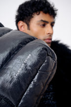 Person wearing a black puffer jacket with 'Yates of Yoros' branding.