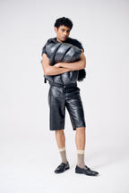 Person wearing a futuristic outfit with a metallic vest and shorts on a white background