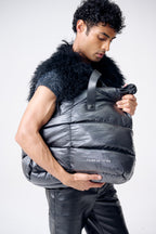 Person wearing a gray puffer vest with fur collar on a white background