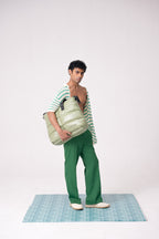 Man holding a large green bag on a white background