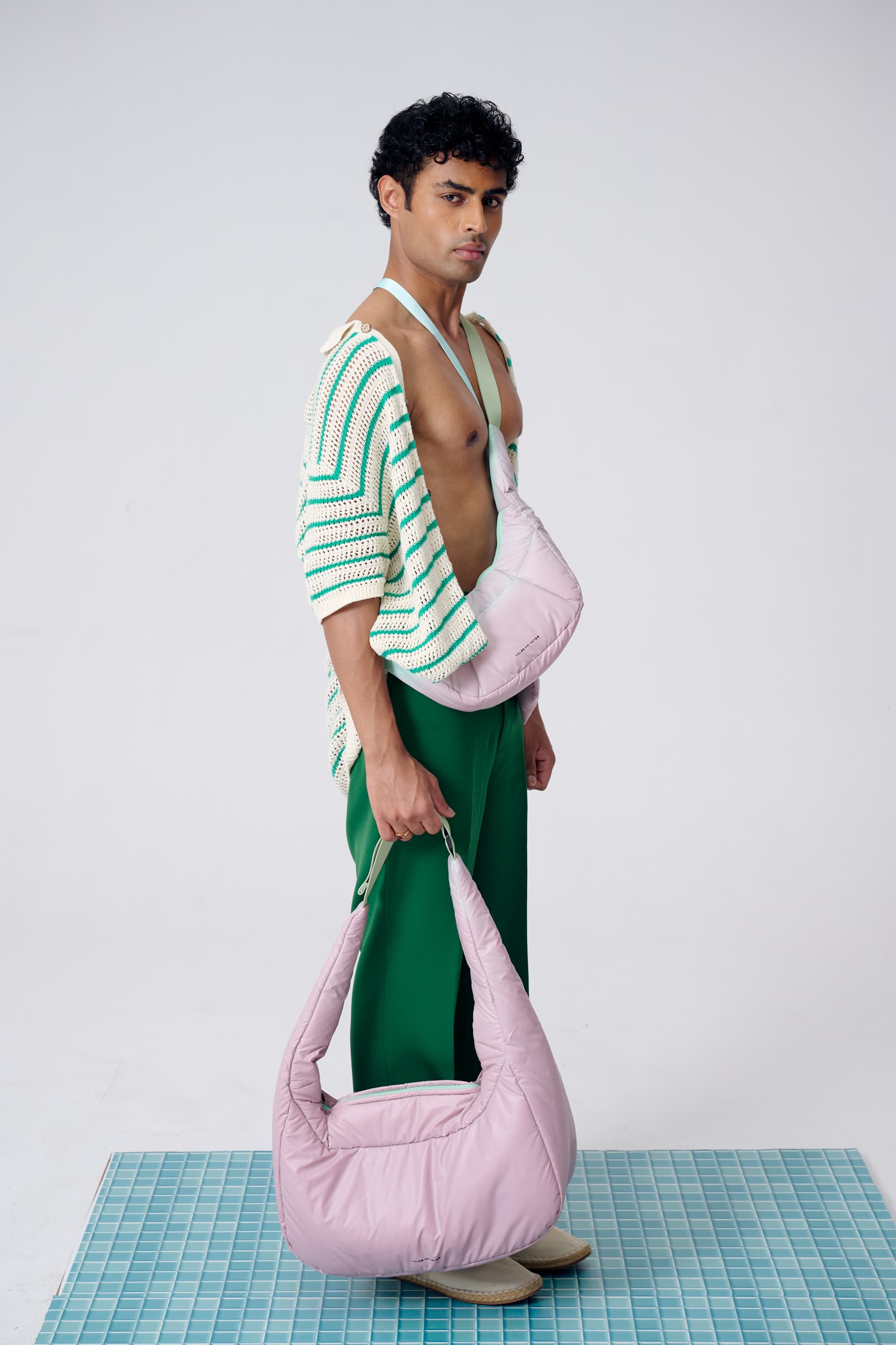Man holding a pink bag with a white background