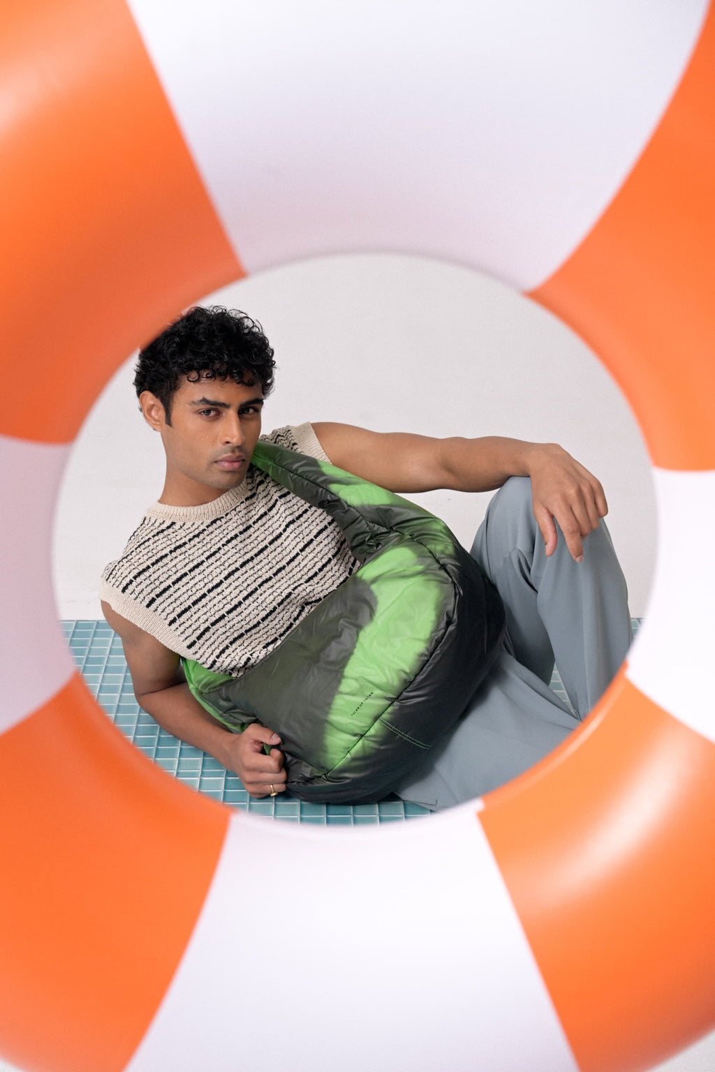 Person sitting on a bean bag chair with an orange and white circular background