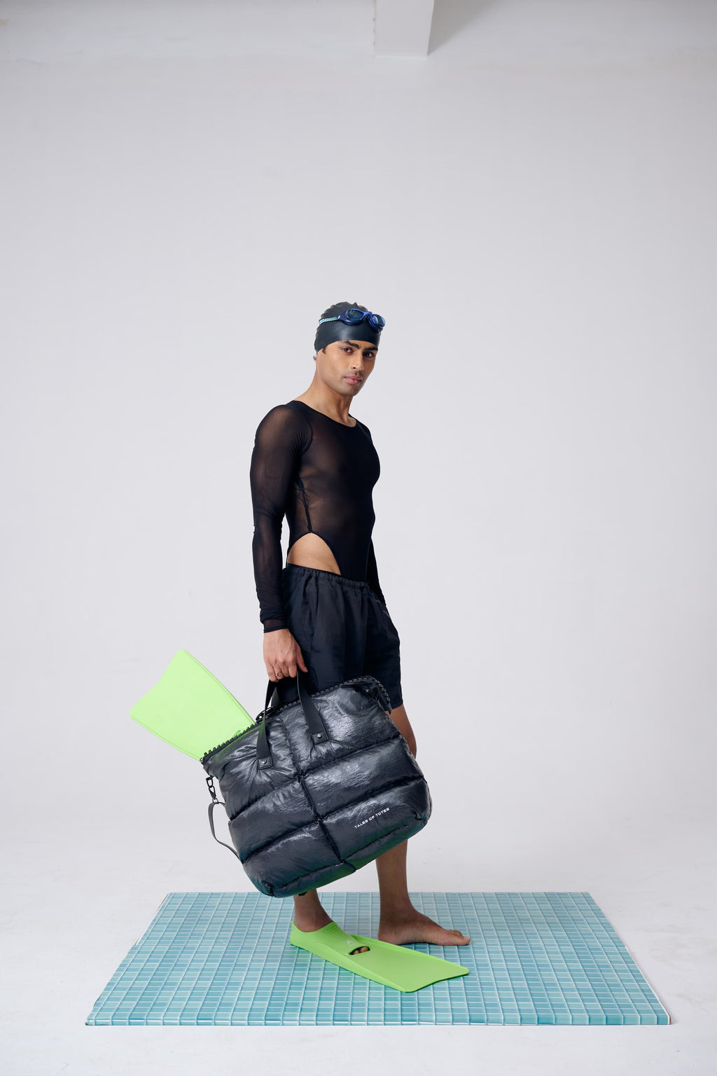 Person holding a bag on a checkered mat with a plain background