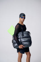 Person holding a large black bag with a white background