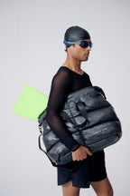 Person holding a large black bag with a white background