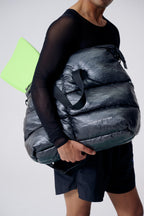 Person holding a large gray backpack with a white background