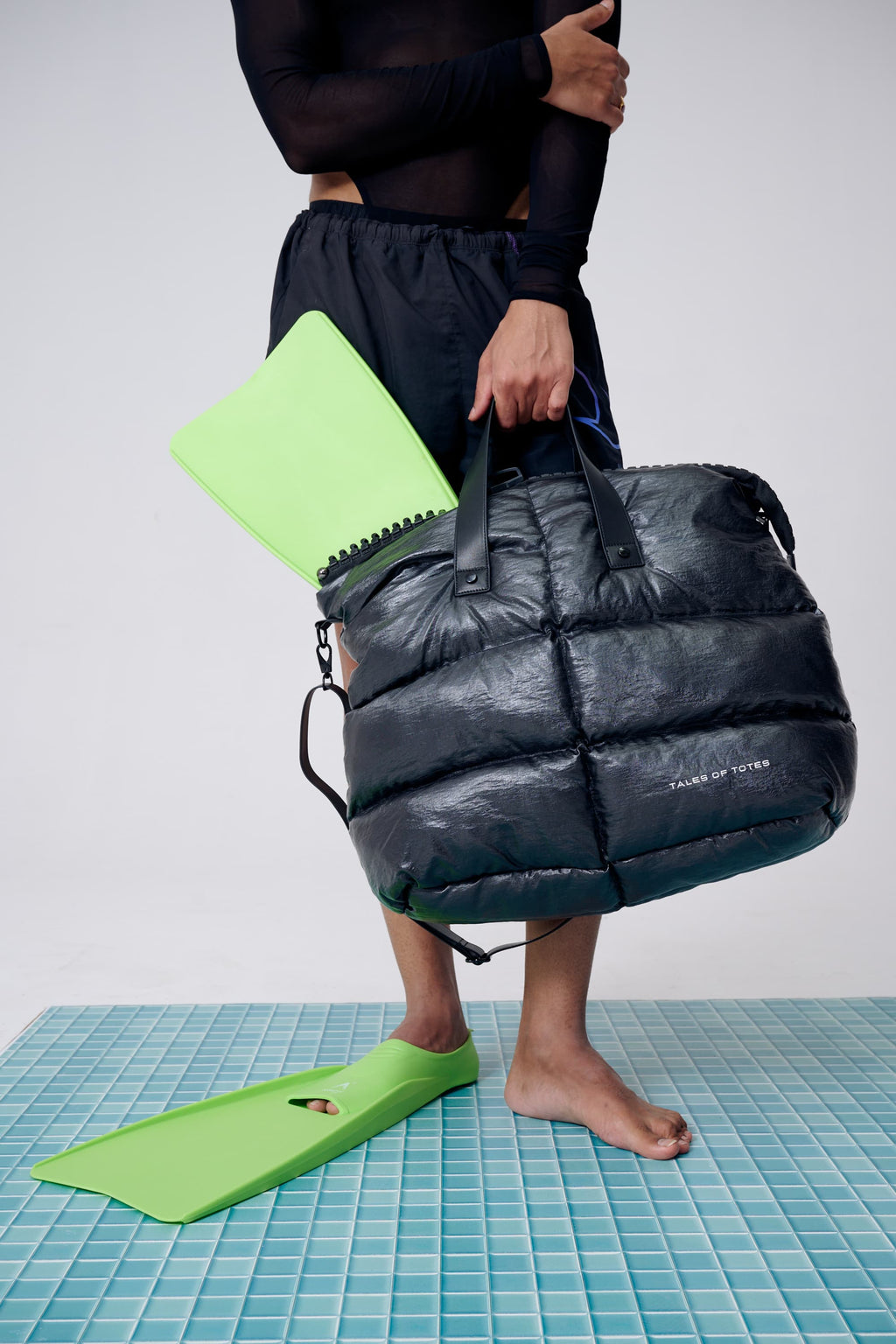 Person holding a black puffer bag with a white background