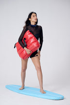 Person holding a red inflatable raft on a white background