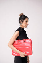 Woman holding a pink clutch bag against a white background