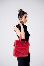 Woman holding a red handbag against a white background