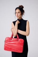 Woman holding a red bag against a plain background