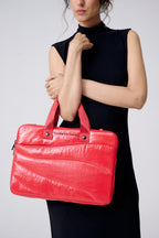 Woman holding a red handbag with a plain background