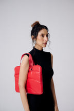 Woman wearing a red backpack against a gray background