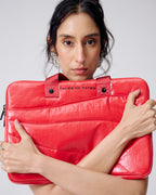 Person holding a red leather briefcase with 'Tales of Totes' branding on a light gray background