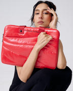 Person holding a red laptop case with 'Tales of Totes' branding against a white background