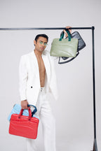 Man holding a red bag and a green handbag against a white background