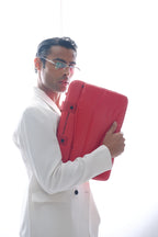 Man holding a red folder against a white background