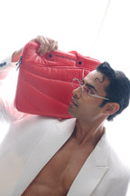Man holding a red bag with a white background