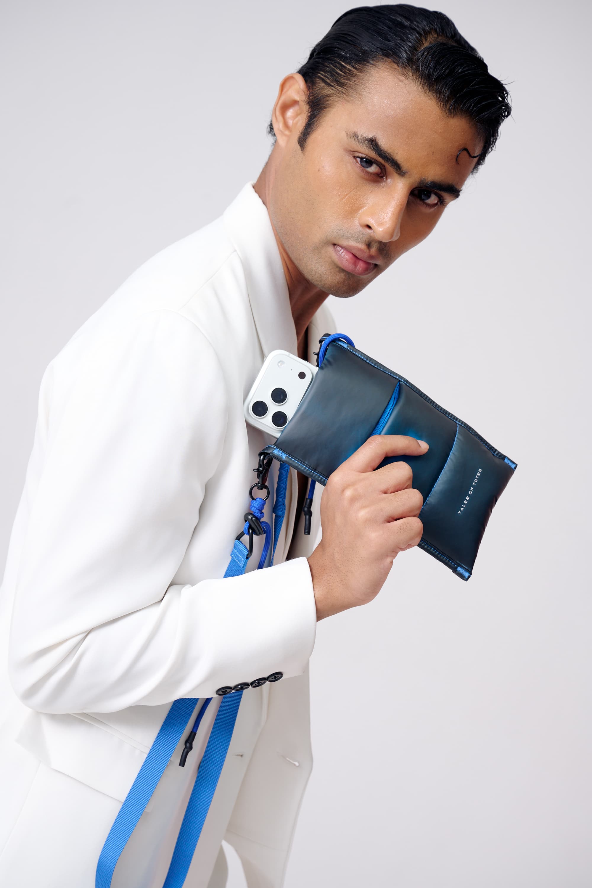 Man holding a blue phone case against a white background