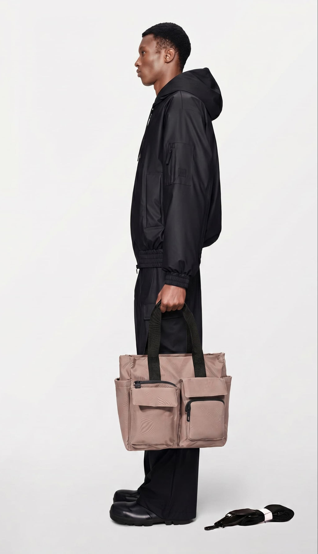 Person holding a beige tote bag against a white background