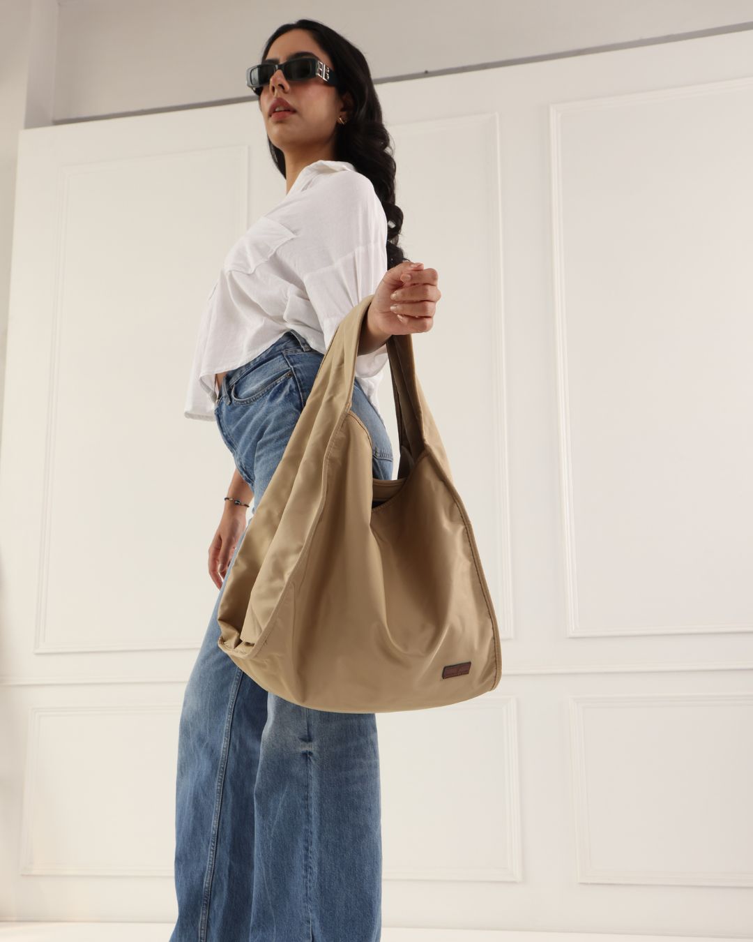 Minimalist black tote bag with a padded top handle, detachable crossbody strap, and front zipper pocket – made from water-resistant fabric for everyday functionality. Lightweight yet spacious, ideal for travel, office, gym, or casual use. A sleek and versatile design by Tales of Totes, offering modern utility and elevated style for Indian shoppers."