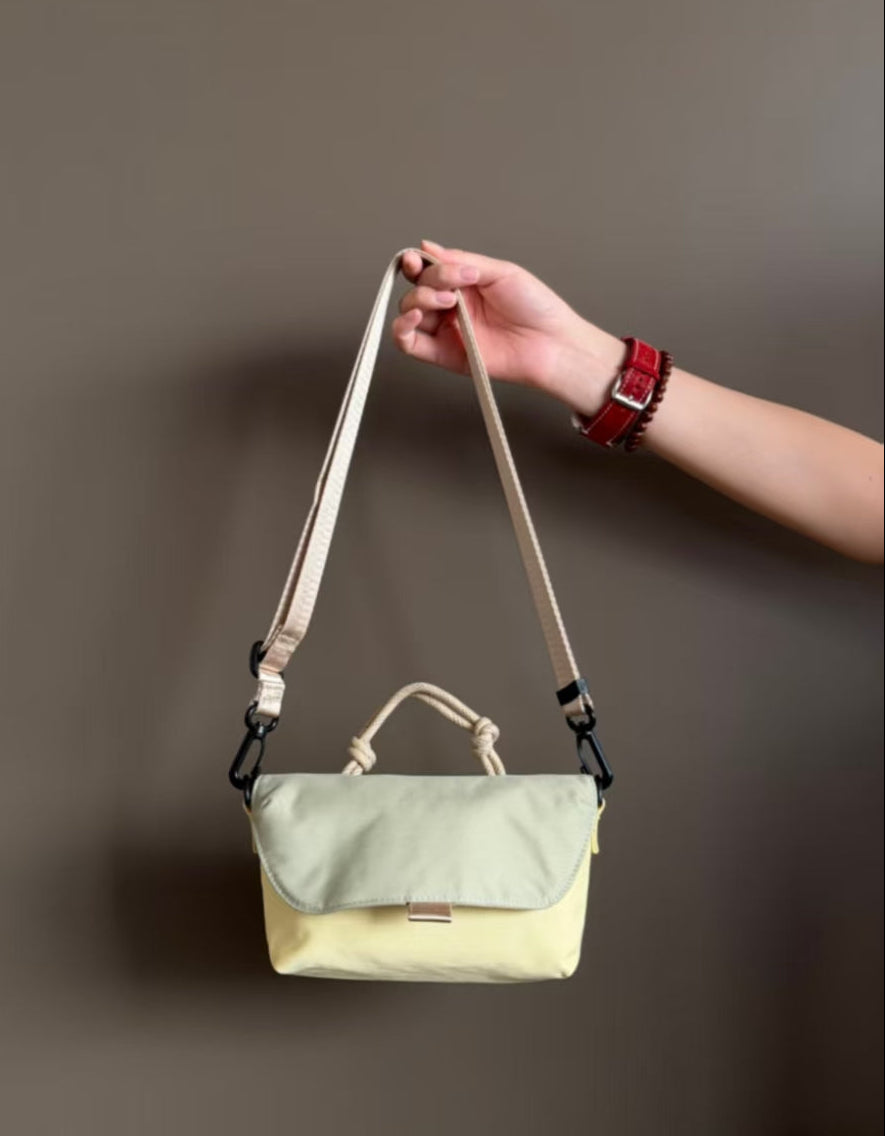 Compact, functional and made to stand out.

Designed for everyday movement, this crossbody bag pairs a clean, softly structured body with contrast utility details. The curved front flap keeps the silhouette minimal, while the bold webbing strap and knotted rope handle give it a sporty, technical edge.

Wear it crossbody for everyday errands, over the shoulder, or carry it by the rope handle when you want to switch things up. Lightweight and easy to style, it’s sized for your daily essentials without feeling