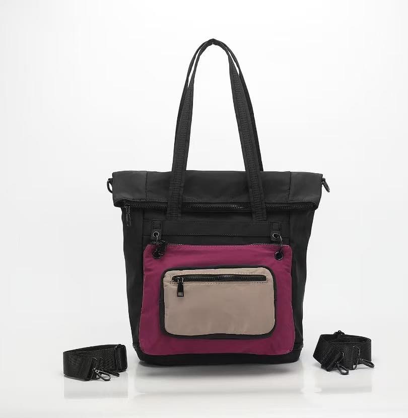 Black tote bag with pink and beige sections on a white background