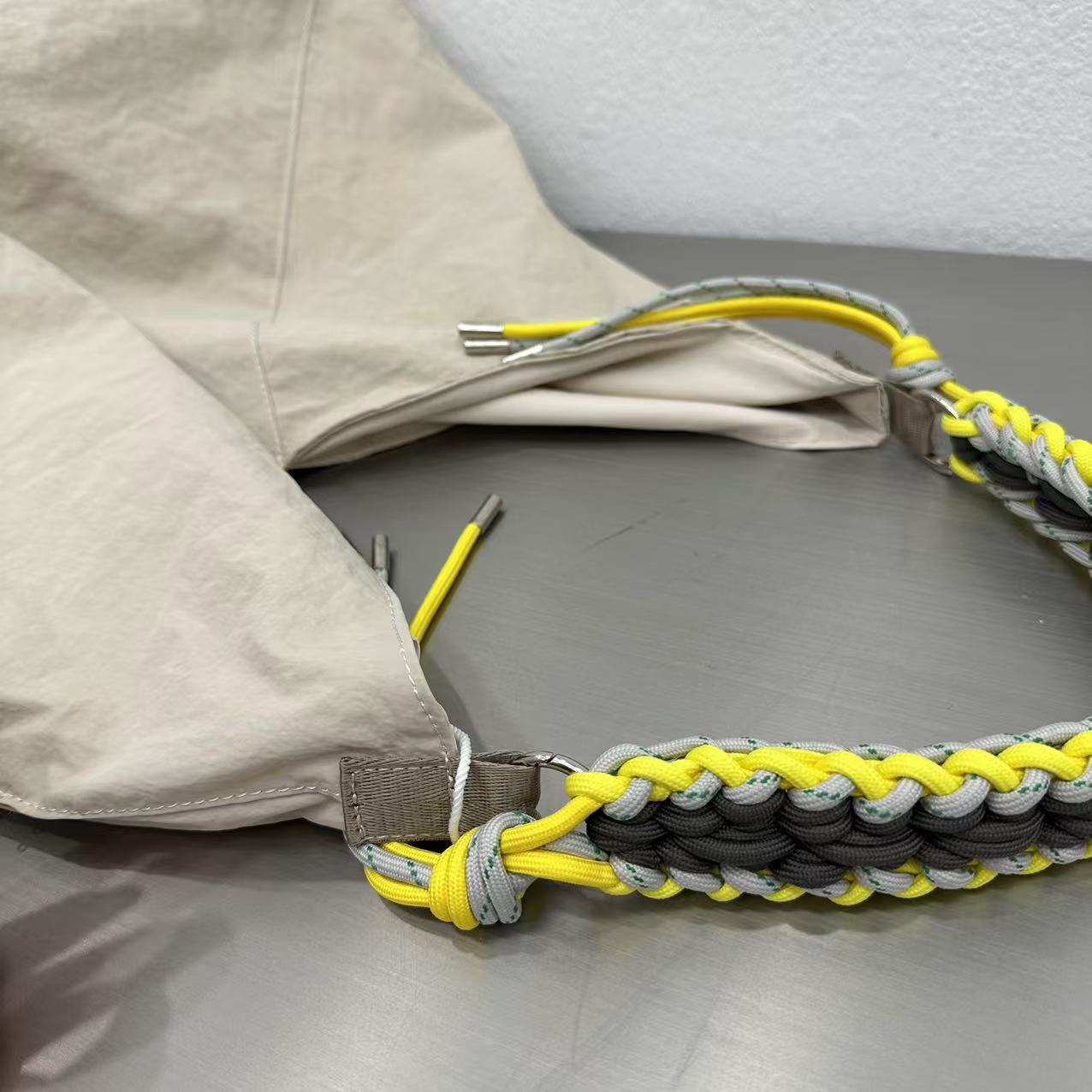 Paracord dog leash with yellow, gray, and black pattern on a gray surface. Person holding a gray tote bag in an indoor setting,“Trendy tote bag for women in India with spacious design, inner pocket, and rope handle strap – perfect everyday alternative to Zara tote bags, H&M shopper bags, Mango handbags, Charles & Keith totes, Lifestyle handbags, Myntra handbags, and Fabindia casual totes.”